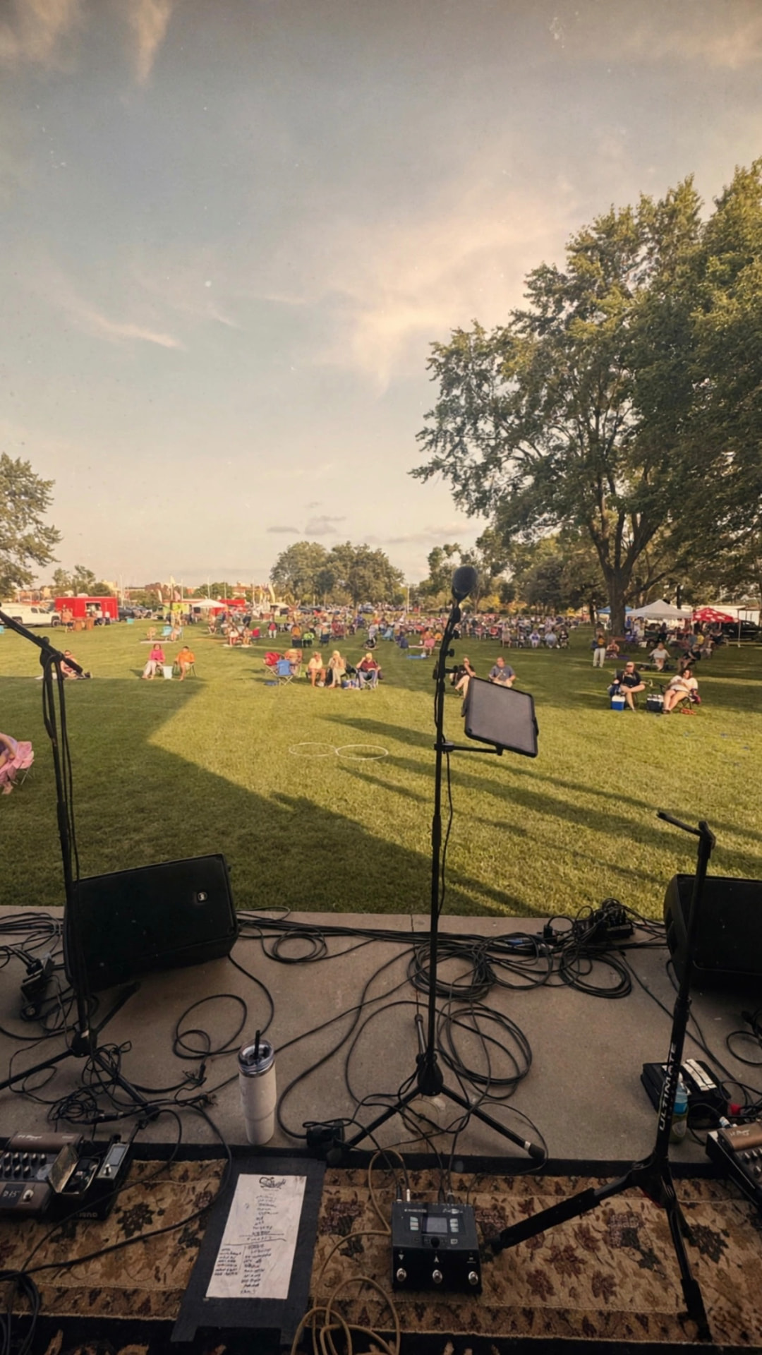 View from the stage at an outdoor festival with a crowd on the lawn